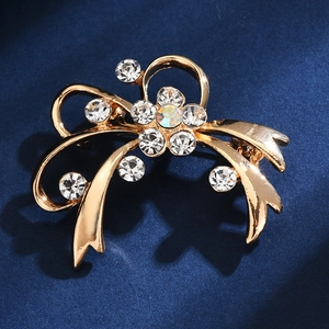 Close-up of golden alloy flower brooch with sparkling rhinestones on blue velvet