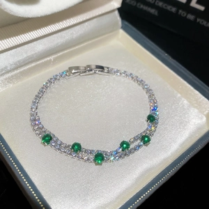 Close-up of 18k gold plated double-layer bracelet with sparkling green and clear zircons
