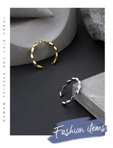 Detailed view of geometric faceted open rings in gold and silver on stone props