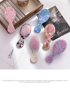 Flat lay of colorful marble-textured mini air cushion hair combs on a white surface