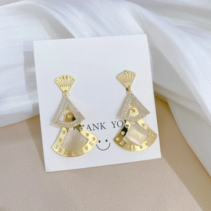 Detailed close-up of fan-shaped dangling earrings with gold plating and zircons