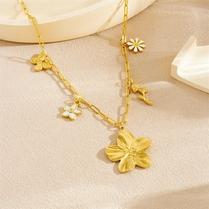 Gold-plated paperclip necklace with mixed floral and butterfly charms on a beige surface