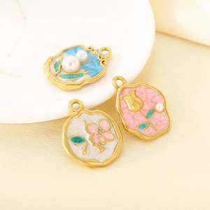 Trois pendentifs vintage en émail plaqué or 18K avec motifs floraux et perles sur plat