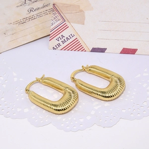 Detailed macro shot of vintage U-shaped chunky gold earrings with twisted rope texture