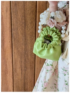 Detail of green mini drawstring handbag for girls with pearl flower wristlet strap