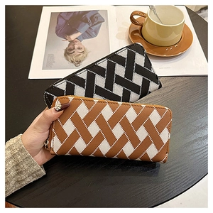 Close-up of the textured woven leather wallet in brown and black color contrast patterns