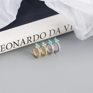 Detailed macro view of gold and silver S925 sterling silver turquoise hoop earrings