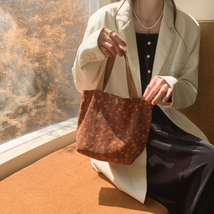 Detail of retro corduroy handbag with floral patterns and textured fabric surface