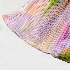 Detailed macro shot of high-quality rainbow gradient pleated fabric on the dress hem