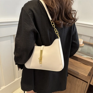 Minimalist beige underarm bag with gold metal hardware and chain strap detail