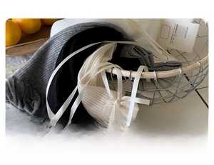 Detail of ballet style knit leg warmers with silk ribbons in a vintage basket