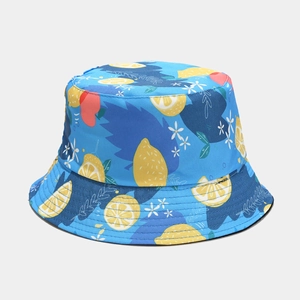Detail shot of blue reversible bucket hat with lemon and berry patterns and fine stitching