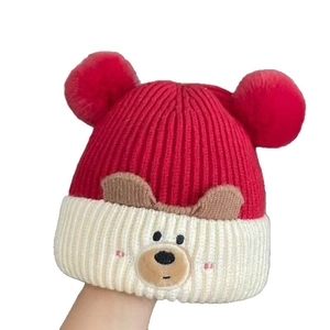 Cute red and white knitted baby winter hat with cartoon bear ears and fluffy pom-poms