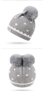 Detail of gray knitted baby hats with soft pom-poms and white polka dot patterns