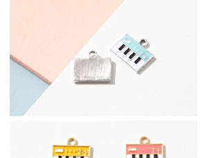 Detailed view of colorful enamel piano keyboard charms in pink, yellow and light blue