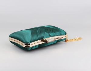 Detail view of emerald green satin evening bag with gold metal frame and crystal clasp