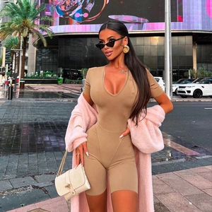 Street style shot of a woman in a camel tight short sleeve bodysuit with a fuzzy pink jacket