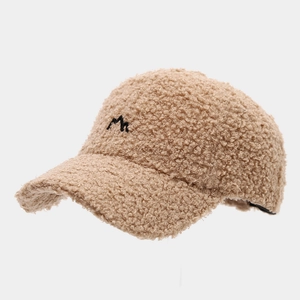Detailed close-up of beige sherpa baseball cap featuring a black embroidered M logo