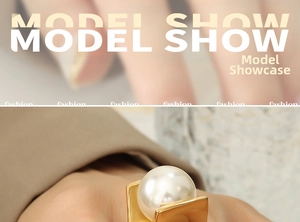 Close-up of a large white pearl ring on a geometric gold band with a warm luxury aesthetic