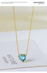Macro view of heart-shaped blue zircon pendant on a gold titanium steel chain necklace