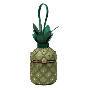 Detail of green pineapple shaped handbag featuring metallic gold studs and leather texture