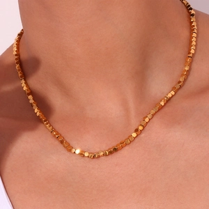 Close-up of minimalist 18K gold plated stainless steel necklace with small cube beads