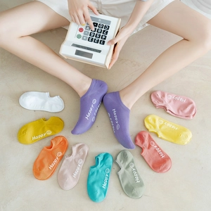 Close-up of colorful cotton low cut socks featuring Happy text and smiley face patterns