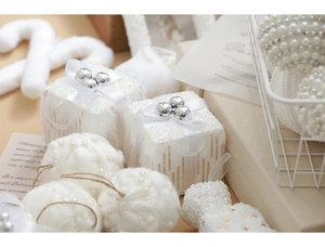 Detail of white Christmas baubles with pearl accents and sparkling ribbon gift box charms