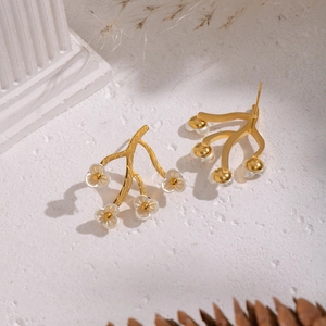 Elegant 18K gold branch earrings with five delicate white flowers on a white pedestal