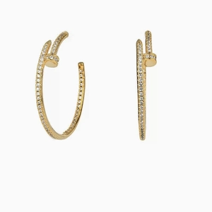 Orecchini a cerchio dorati a forma di chiodo con zirconi in uno stile minimalista
