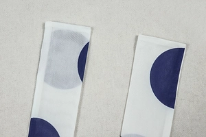 Detailed close-up of breathable white mesh fabric with large blue polka dots pattern