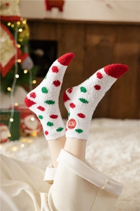 Detail of soft coral fleece Christmas socks featuring red and green dots and JOY label