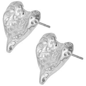 Macro shot of silver heart studs with unique irregular hammered texture and metallic shine