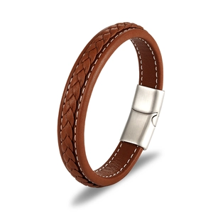 Close-up of brown braided leather bracelet with contrast stitching and silver magnetic clasp