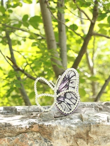 Close-up of butterfly evening bag with purple fabric and sparkling rhinestone wing details