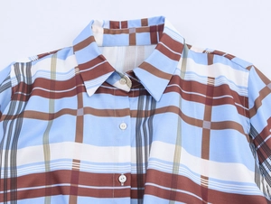 Detail view of plaid shirt collar with blue brown patterns and white round buttons