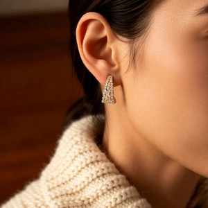 Gros plan de boucles d'oreilles en U plaquées or 18 carats avec oxydes de zirconium blancs