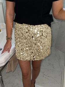 Detail of elegant gold sequin mini skirt with bodycon fit shown in lifestyle setting