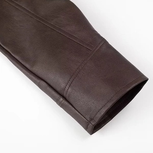 Close-up of dark brown leather sleeve cuff with detailed stitching on a coat