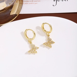 Detailed close-up of gold butterfly hoop earrings with sparkling cubic zirconia crystals