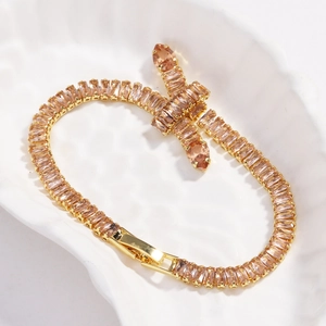 Detailed macro shot of champagne zircon stones in a gold knotted tennis bracelet design