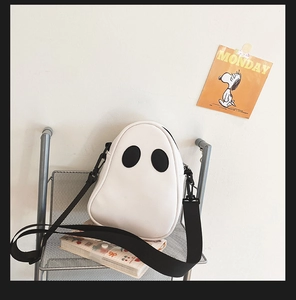 Detail shot of the white ghost-shaped PU leather crossbody bag with wide black strap