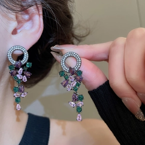 Detail of zircon tassel earrings with purple teardrop crystals on gunmetal finish