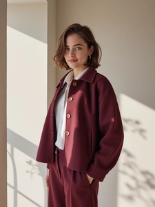 Detailed close-up of a burgundy wool jacket featuring a lapel collar and light buttons