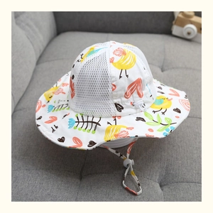 Dettaglio cappello sole neonato con rete traspirante bianca e stampe di uccellini