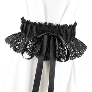 Close-up of black lace waist belt with large ribbon bowknot on white dress