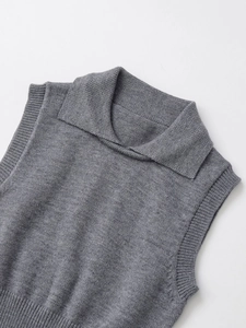 Detailed view of gray knit vest featuring a classic collar and ribbed edges texture