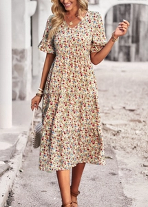 Close-up detail of V-neck floral midi dress with puff sleeves and tiered skirt texture