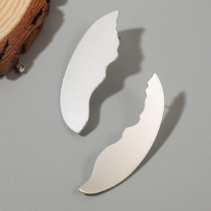 Detail view of matte silver abstract wave earrings showing the brushed metallic texture