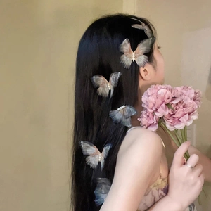Detailed view of layered butterfly hair clips with delicate pearls on a long hairstyle
